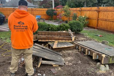Rapid Junk Removal RI crew demolishing and removing a large wooden deck in Providence, RI, including debris removal and disposal.
